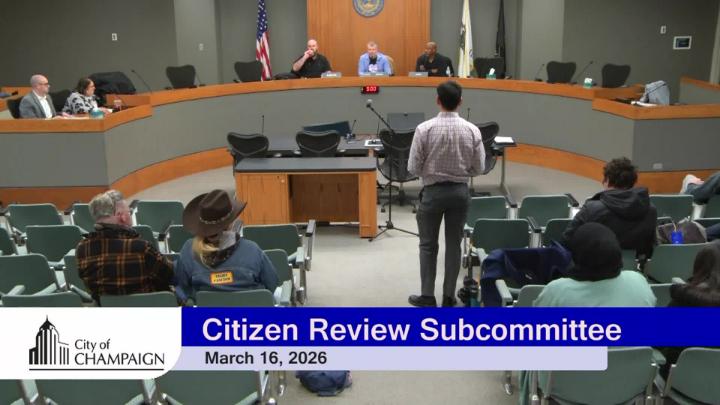 Wide shot of Audience and Dias. Audience Member standing to get ready for public participation. 